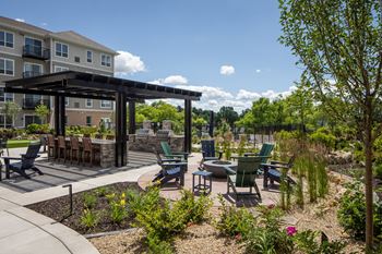 an outdoor patio with tables and chairs and a building in the background